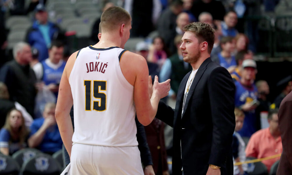 Luka Doncic #77 of the Dallas Mavericks talks with Nikola Jokic #15 of the Denver Nuggets...
