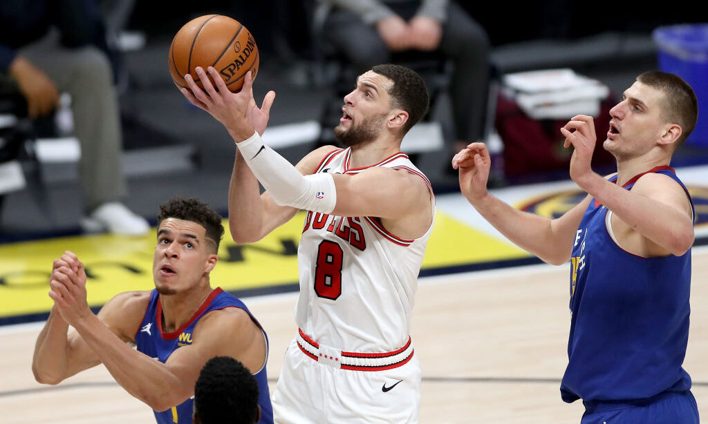 Zach LaVine #8 of the Chicago Bulls goes to the basket against Michael Porter Jr. #1 and Nikola Jok...