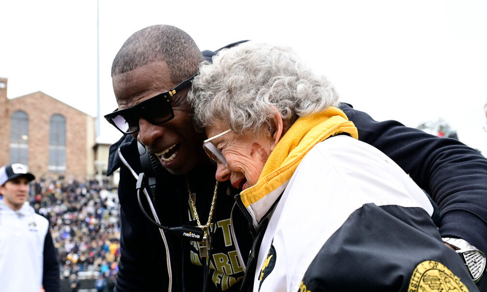CU Buffs head coach Deion Sanders hugs super fan, Peggy Coppom,...