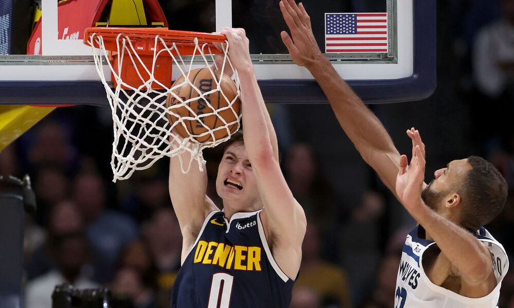 Christian Braun #0 of the Denver Nuggets dunks Rudy Gobert #27 of the west foe Minnesota Timberwolv...