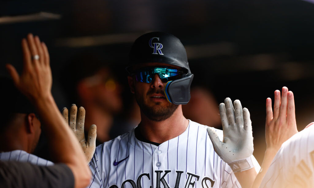 ULY 24: Kris Bryant #23 of the Colorado Rockies is congratulated in the dugout by teammates after s...
