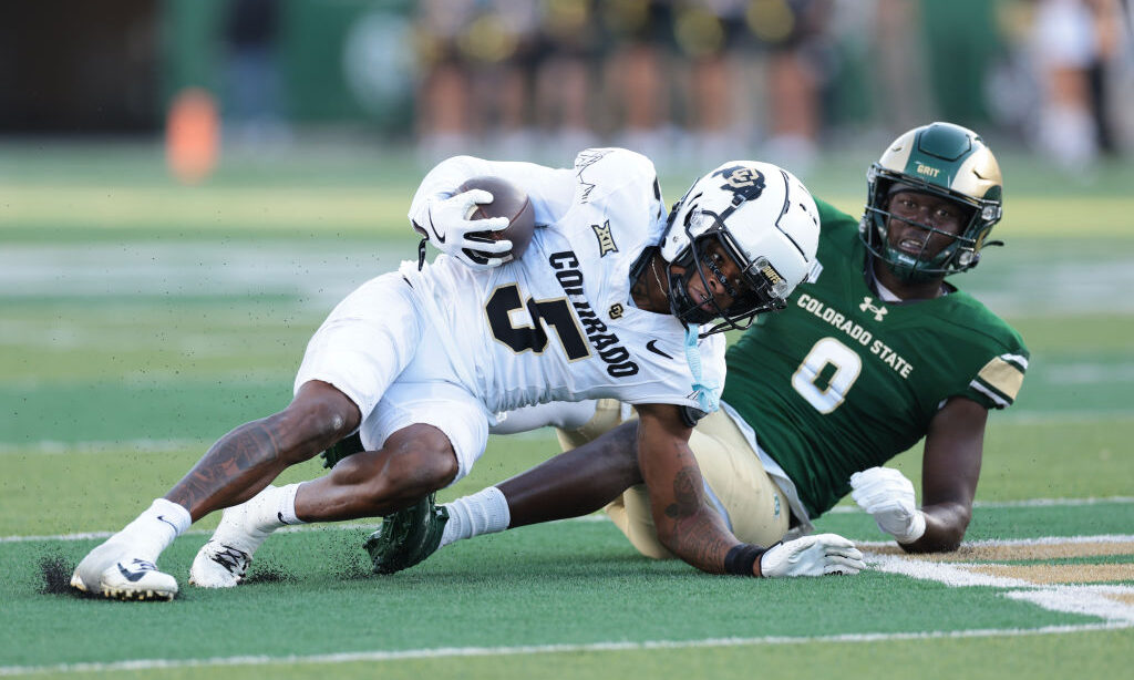 Jimmy Horn Jr. #5 of the Colorado Buffaloes is tackled by Chris Jackson #0 of the Colorado State Ra...