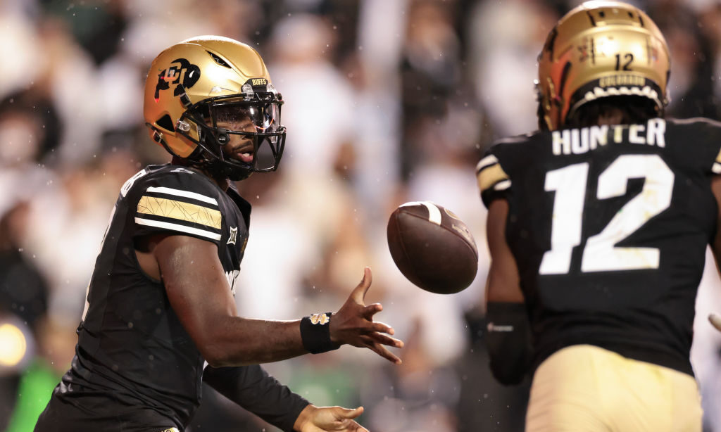 Shedeur Sanders #2 tosses the ball to Travis Hunter #12 of the Colorado Buffaloes...