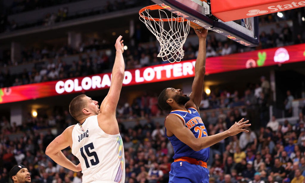 Mikal Bridges #25 of the New York Knicks drives to the basket against Nikola Jokic #15 of the Denve...