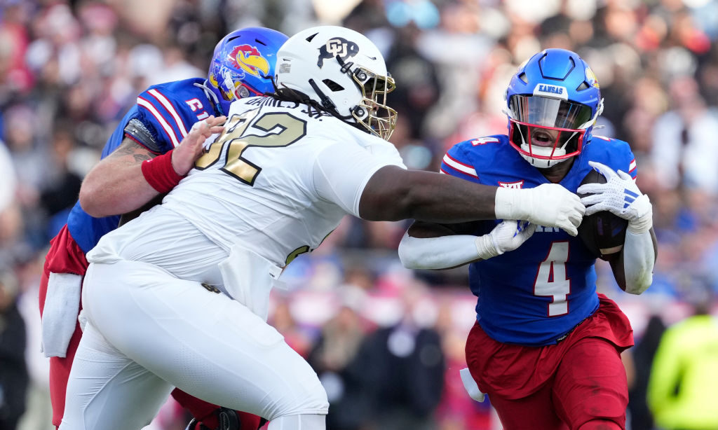 KANSAS CITY, MISSOURI - NOVEMBER 23: Running back Devin Neal #4 of the Kansas Jayhawks runs against...