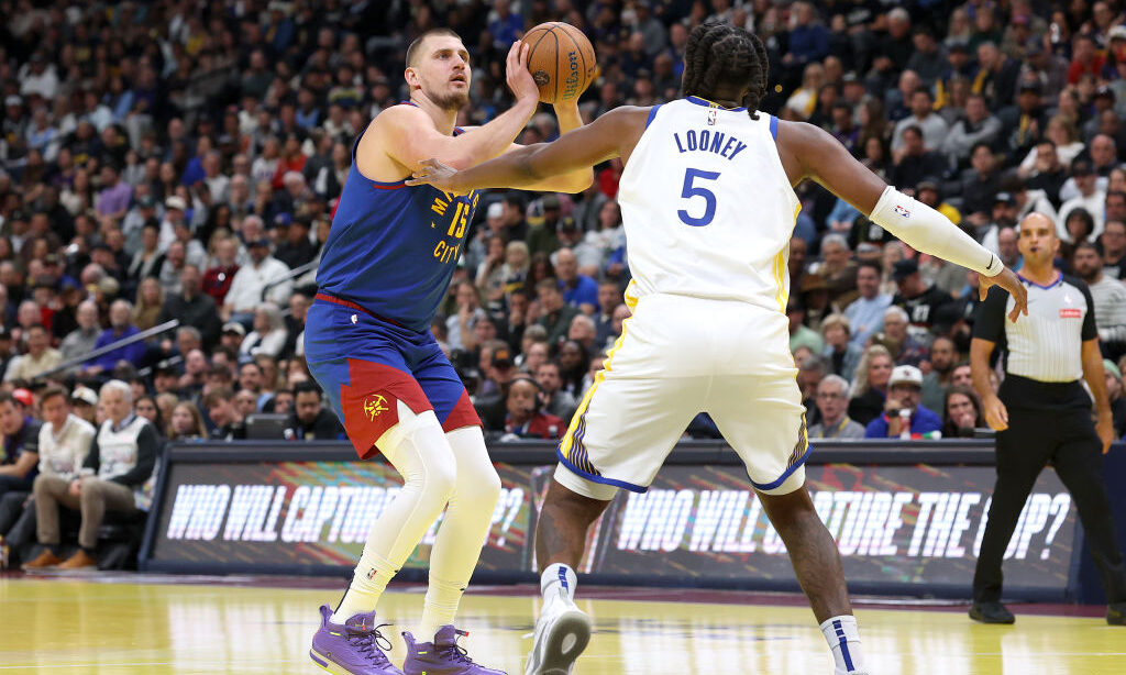 Nikola Jokic #15 of the Denver Nuggets puts up a shot against Kevon Looney #5 of the Golden State W...