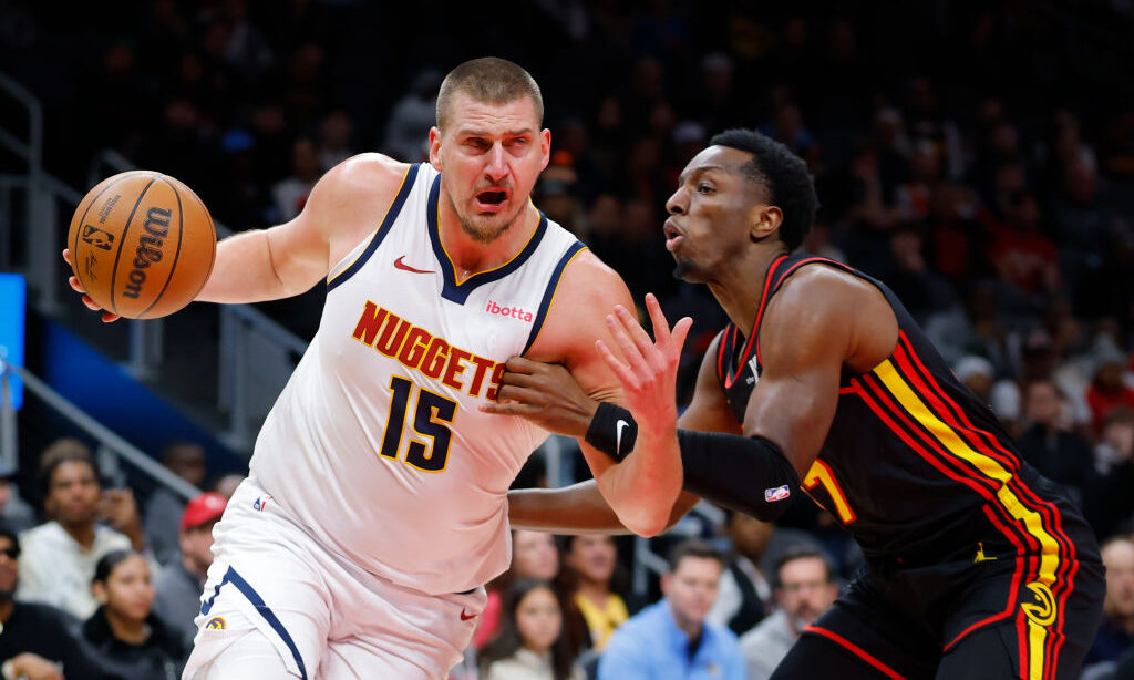 ATLANTA, GEORGIA - DECEMBER 08: Nikola Jokic #15 of the Denver Nuggets drives against Onyeka Okongw...
