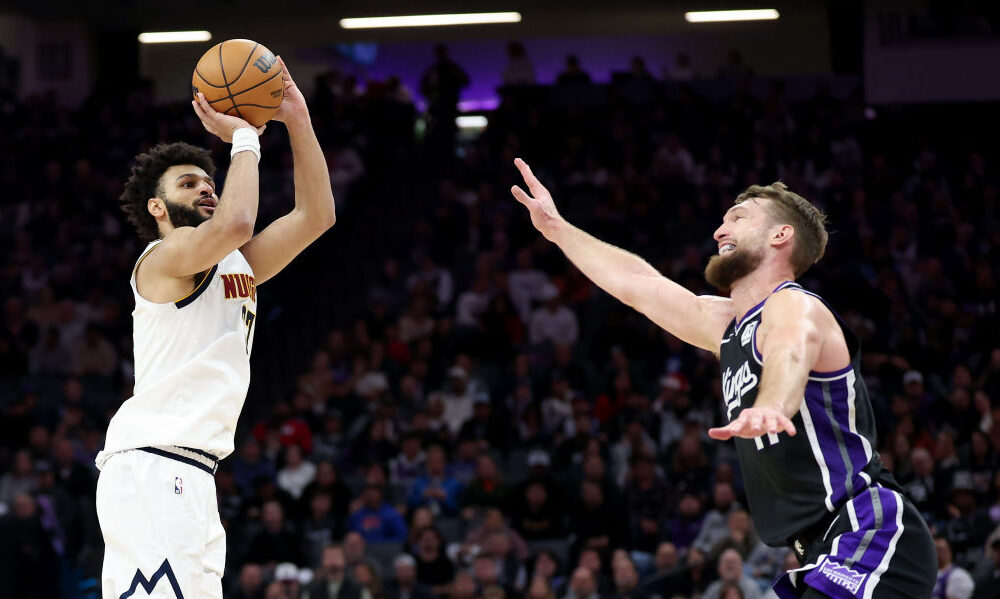 Jamal Murray #27 of the Denver Nuggets shoots over Domantas Sabonis #11 of the Sacramento Kings...