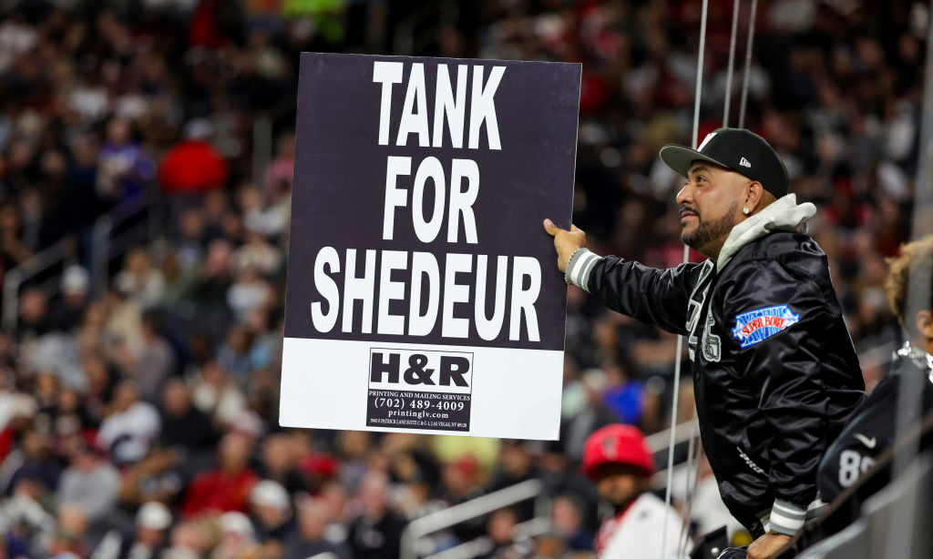 Las Vegas Raiders fan "Vegas" Ralph Sotelo of Nevada holds up a sign referencing quarterback Shedeu...