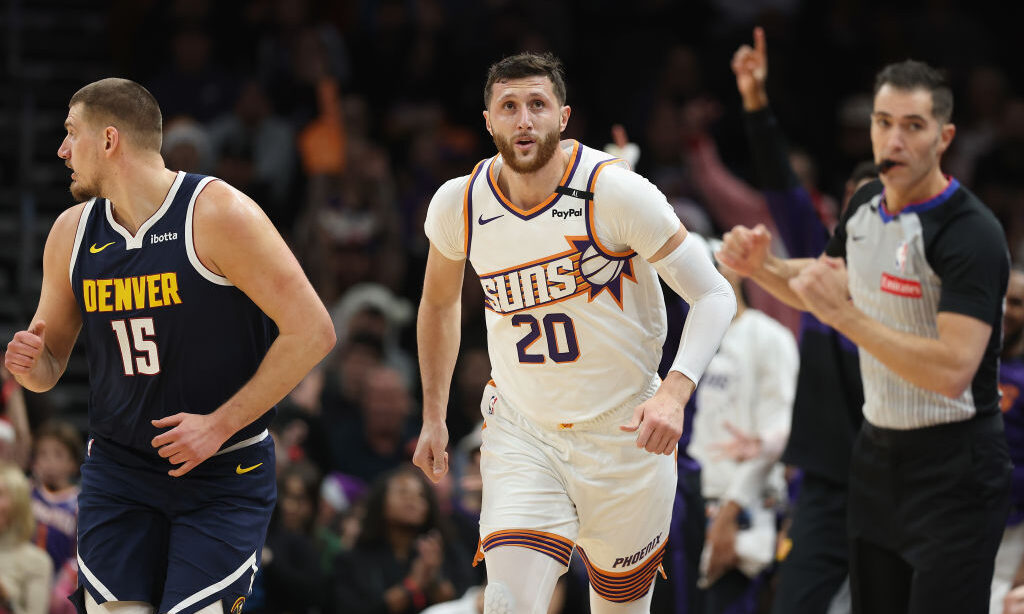 Jusuf Nurkic #20 of the Phoenix Suns reacts to a three-point shot over Nikola Jokic #15 of the Denv...