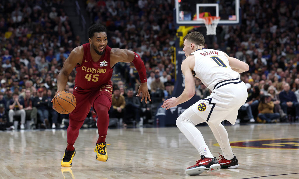 DENVER, COLORADO - DECEMBER 27: Donovan Mitchell #45 of the Cleveland Cavaliers drives against Chri...