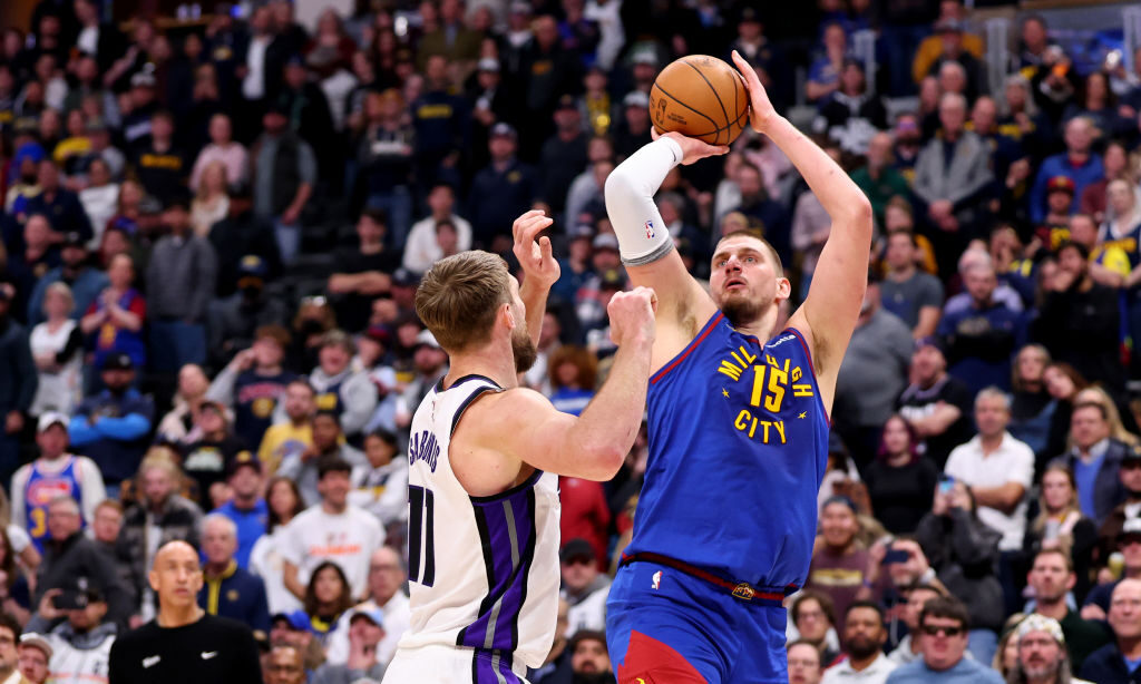 Nikola Jokic #15 of the Denver Nuggets shoots against Domantas Sabonis #11 of the Sacramento Kings ...