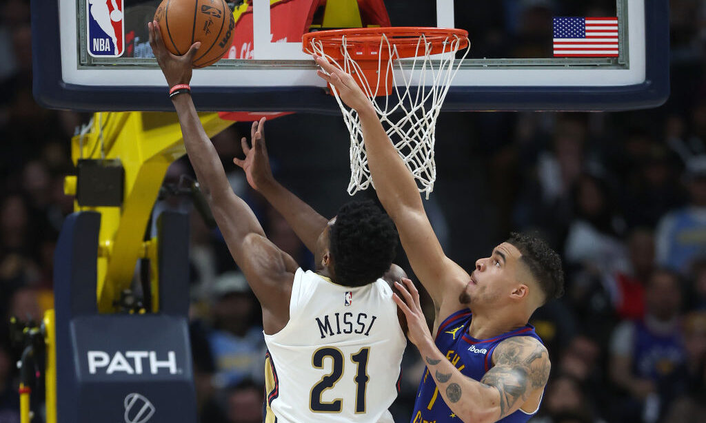 Yves Missi #21 of the New Orleans Pelicans goes to the basket against Michael Porter Jr. #1 of the ...