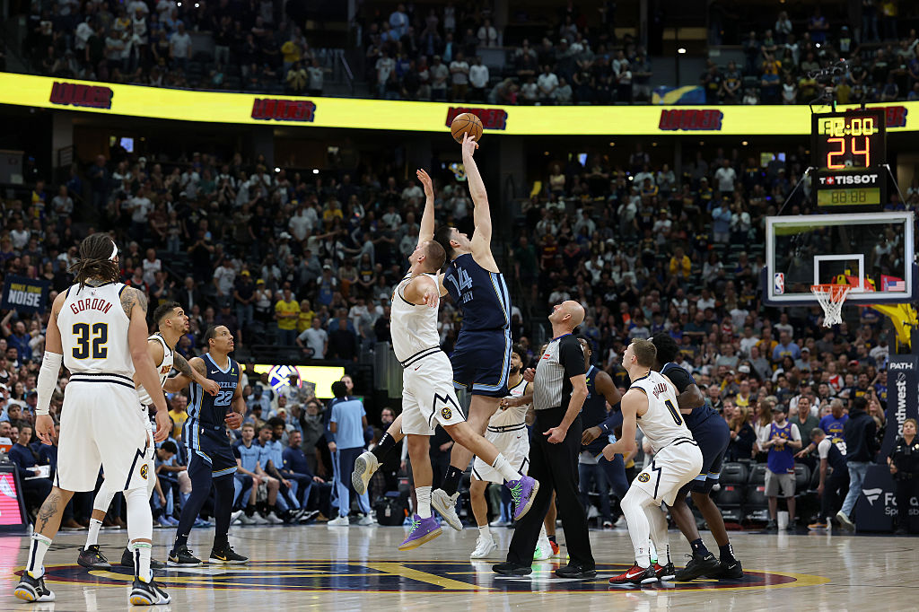 Nikola Jokic #15 of the Denver Nuggets tips off against Zach Edey #14 of the Memphis Grizzlies in t...